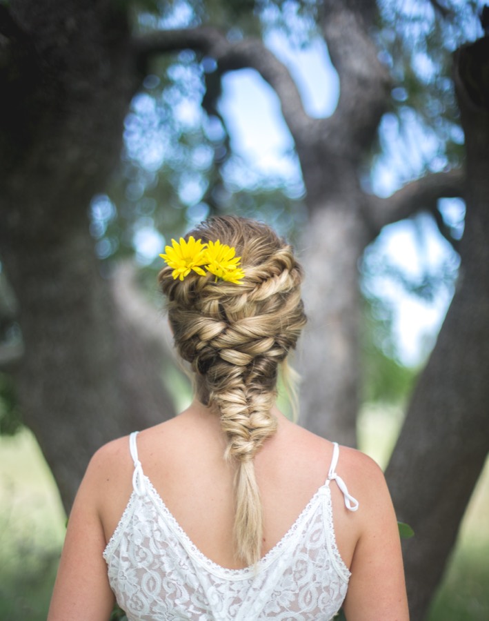 Bridal fishtail braid adorned with yellow daisies