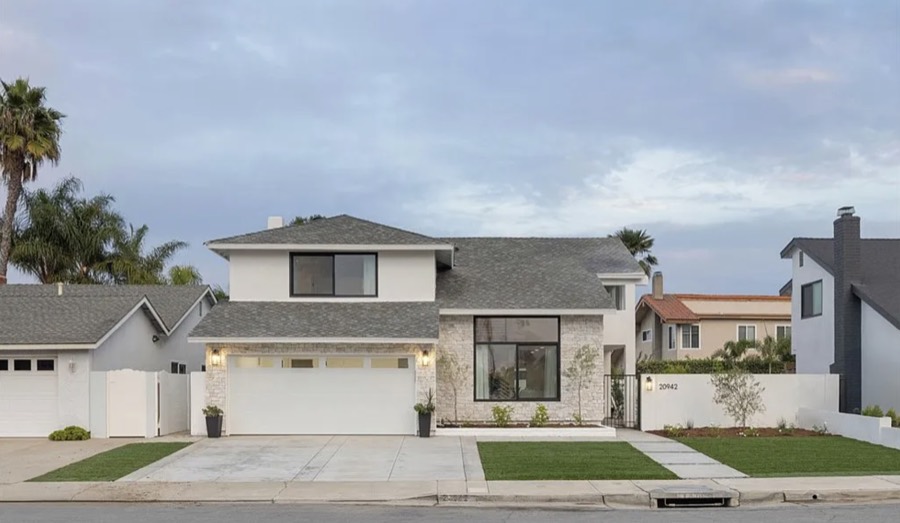 Two-story modern home exterior at dusk with stone facade